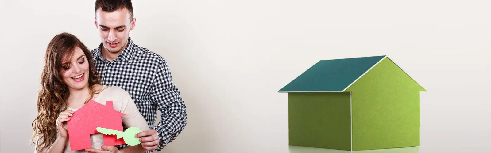 pareja joven al lado de una maqueta de una casa